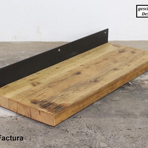 May include: A rustic wooden shelf with a black metal bracket. The shelf is made of reclaimed wood and has a natural finish. The bracket is attached to the underside of the shelf and has a simple design. The shelf is perfect for displaying decorative items or storing small items.