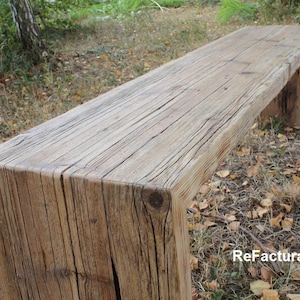 Pu&ograve; includere: Panca in legno rustico dall'aspetto naturale e invecchiato. &Egrave; costruita con spesse assi rettangolari di legno, con venature e nodi visibili. La panca &egrave; all'aperto, circondata dal fogliame.