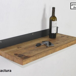 May include: A wooden shelf with a black metal bracket. The shelf is made of reclaimed wood and has a rustic look. A bottle of wine, a phone, and keys are on the shelf.