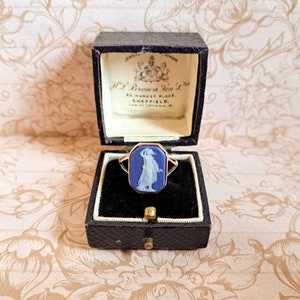 K&ouml;nnte beinhalten: Ein blauer Kameenring mit einer goldenen Fassung, der eine Frau in einem wei&szlig;en Kleid zeigt, in einer schwarzen Ringbox mit dem Text "H. Brown & Son Ltd. 65 Market Place, Sheffield. 120 at London, W."