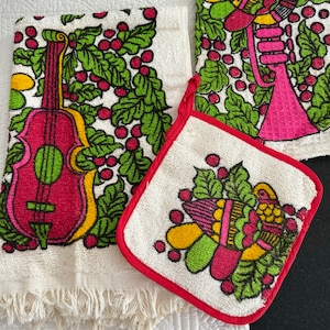 May include: A set of vintage kitchen linens featuring a violin, trumpet, and floral design. The set includes a fringed towel, a potholder with red trim, and a patterned towel. The designs are in shades of pink, green, yellow, and red on a white background.