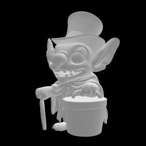 May include: A white figurine of a cartoon character with large ears, a top hat, and a cape. The character is holding a cane and a bucket with a handle. The figurine has a wide grin and is set against a black background.