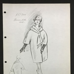 May include: A pencil sketch of a woman wearing a brown coat with a white scarf. The sketch is on a white sheet of paper with the text "X15-700 Brown silk coat" written at the top.