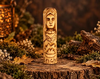May include: A cylindrical wooden carving featuring a detailed face with long hair, a decorative collar, and a flame symbol above the word Bright etched into the surface. The light-colored wood shows natural grain and dark, burned-in details.