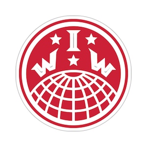 Może przedstawiać: Czerwone koło z białym obramowaniem i białym wzorem w środku. Wzór przedstawia glob z gwiazdą nad nim, dwiema gwiazdami po obu stronach i literami "WI" nad globem.