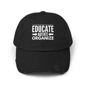 May include: Black distressed baseball cap with white text that reads "Educate Agitate Organize" with arrows pointing in opposite directions.