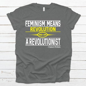 May include: A dark gray t-shirt with the text "Feminism means revolution and I am a revolutionist - Frances Perkins" in white and yellow lettering.
