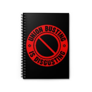 May include: A black spiral notebook with a red circle and the text "UNION BUSTING IS DISGUSTING" in black.