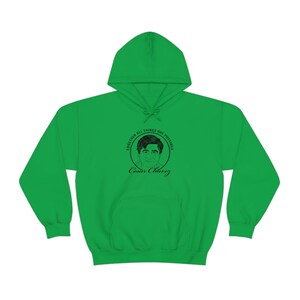 Puede incluir: Sudadera con capucha verde con una ilustración en blanco y negro de Cesar Chavez con el texto "Juntos todo es posible" en un círculo alrededor de la ilustración.