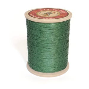 May include: A spool of green linen thread with a label that reads "Lin Cable 500 Metres Successeurs".