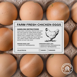 Peut inclure: Une boîte d'œufs de poulet frais de la ferme. Les œufs sont brun clair et reposent dans un emballage en carton. Une étiquette blanche fournit des instructions de manipulation et un dessin d'une poule. Le texte indique "Farm Fresh Chicken Eggs."