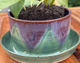 Vaso de cerâmica artesanal com bandeja e furos de drenagem.