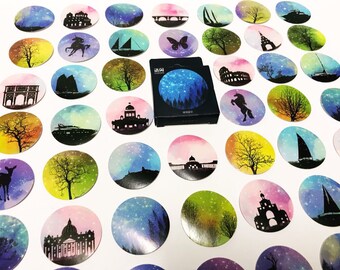 Könnte beinhalten: Ein Set mit 30 runden Aufklebern mit verschiedenen Illustrationen von Gebäuden, Bäumen, Tieren und Booten auf einem sternenklaren Nachthimmel. Die Aufkleber sind auf weißem Papier mit glänzender Oberfläche gedruckt.