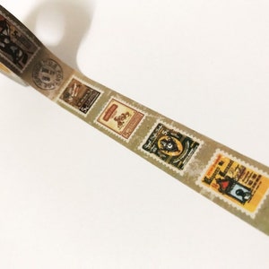 May include: Decorative washi tape featuring a repeating pattern of vintage postage stamps. The stamps have a distressed, aged appearance with various designs and colors, including brown, yellow, and blue. The tape is on a white background.