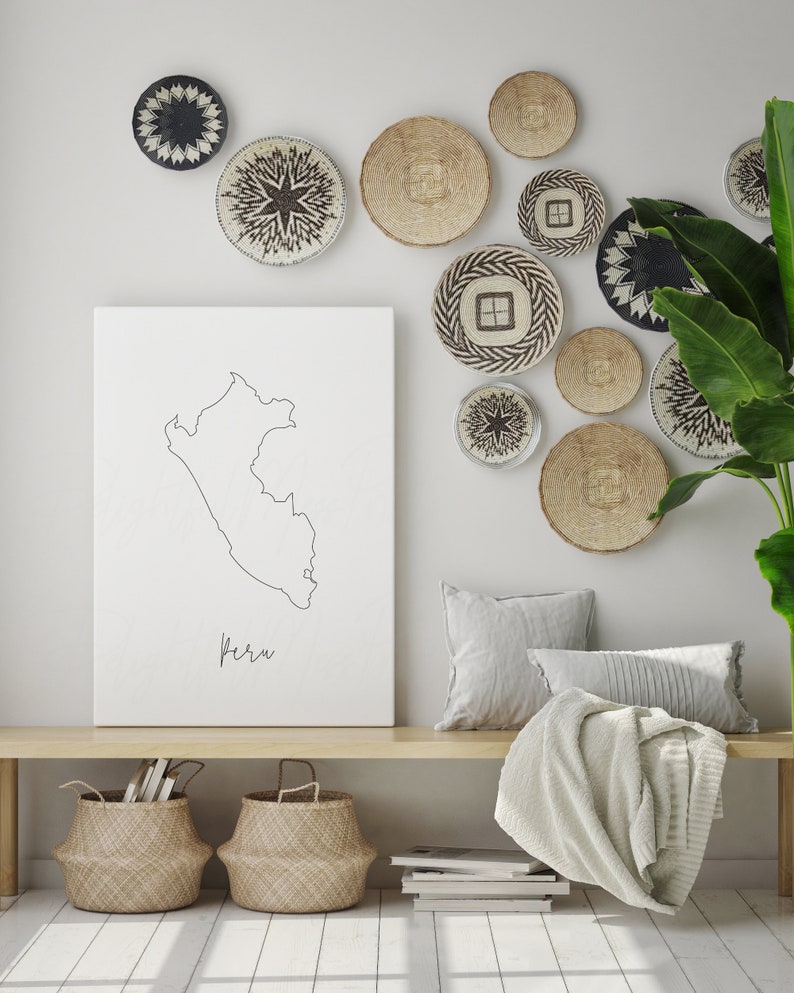 May include: A neutral-toned interior with a wooden bench, woven baskets, and a canvas print of Peru. The wall is decorated with woven wall hangings in different sizes and patterns. A blanket and pillows are arranged on the bench.