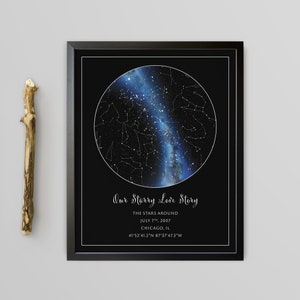 May include: Framed print featuring a celestial map within a black frame. The artwork displays a detailed depiction of stars and constellations against a dark blue and black background. Text reads "Our Starry Love Story" with date and location details.