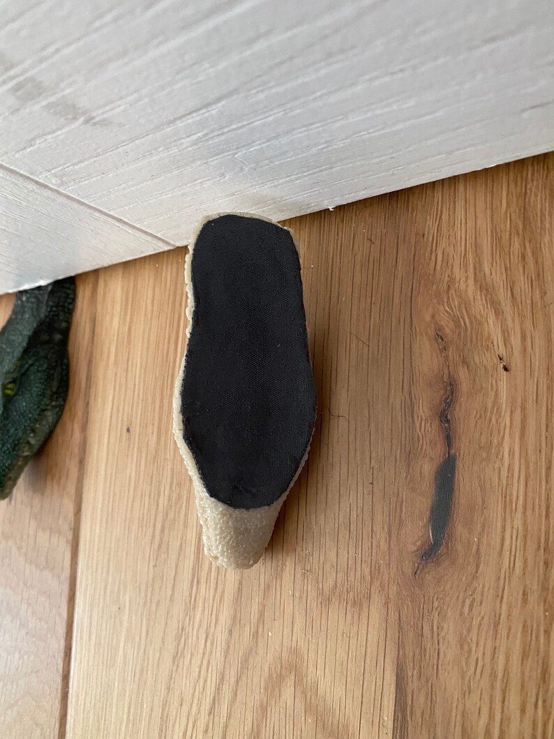 May include: A beige and black shoe sole with a textured surface.