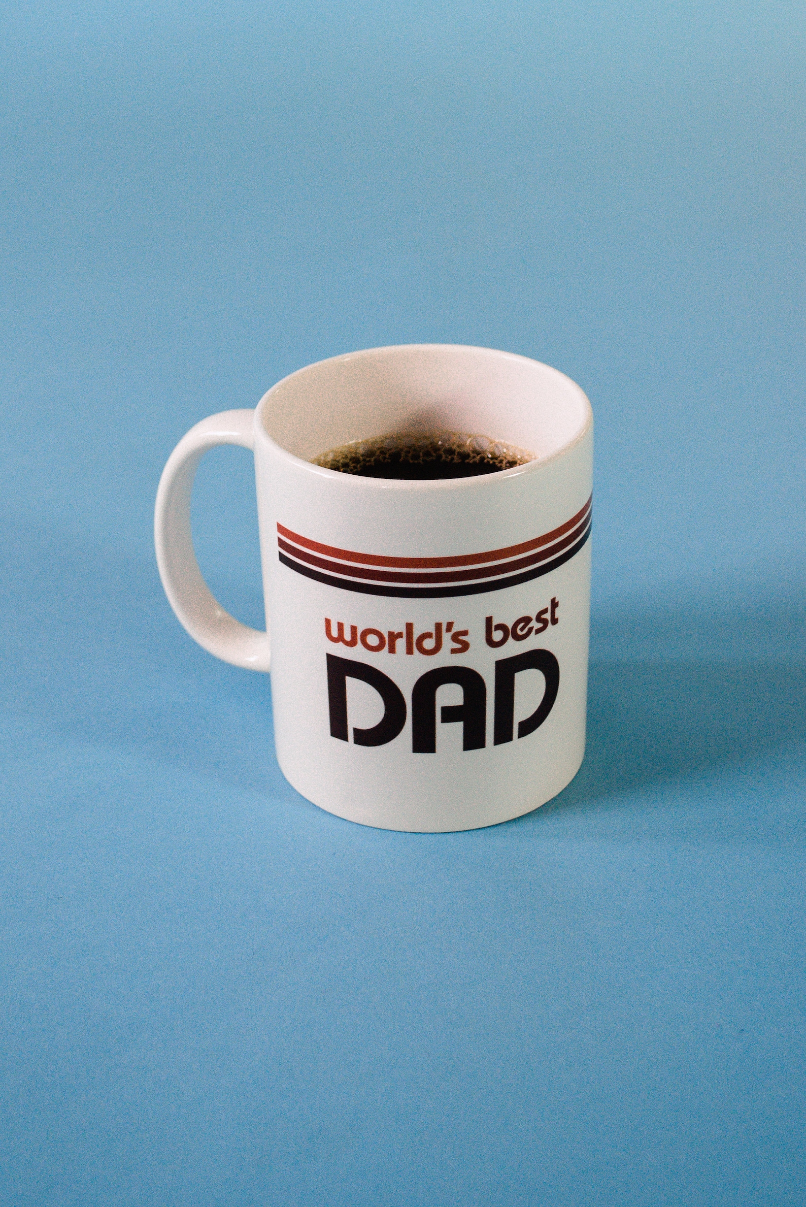 A white mug filled with coffee with retro text on it