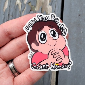May include: A sticker featuring a cartoon character with brown hair and a red shirt. The character has large eyes and is smiling. Text on the sticker reads "Will You Be My Giant Woman?"