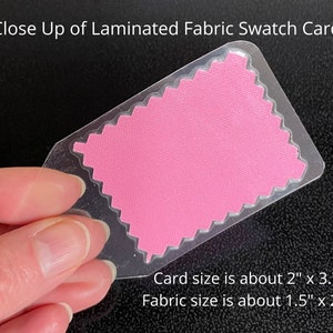 May include: Close-up of a pink fabric swatch card. The card is laminated and measures approximately 2 inches by 3.75 inches. The fabric swatch itself is about 1.5 inches by 2.25 inches.