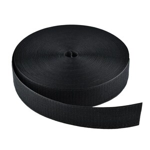 May include: A roll of black hook and loop tape, often called Velcro, is shown against a white backdrop. The tape is coiled, with a section unrolled, revealing the textured surface. Suitable for various crafting and fastening applications.