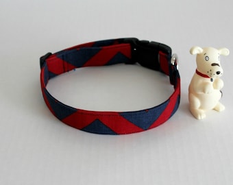 Puede incluir: Un collar para perro con estampado de chevron rojo y azul marino con una hebilla de plástico negra.