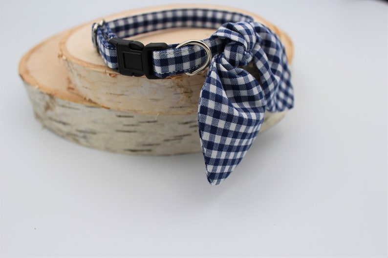K&ouml;nnte beinhalten: Ein blaues und wei&szlig;es Gingham-Hundehalsband mit passendem Fliege. Das Halsband ist verstellbar und hat eine Metallschnalle.