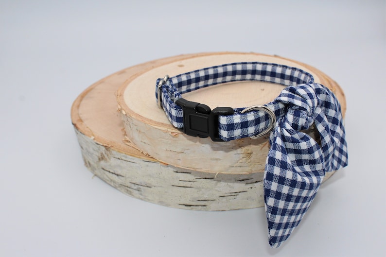 K&ouml;nnte beinhalten: Ein blaues und wei&szlig;es Gingham-Hundehalsband mit einer schwarzen Schnalle und einer passenden Schleife.