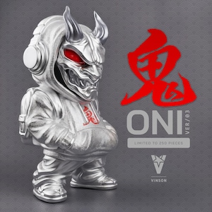 May include: A silver-colored Oni figure with red eyes and horns, wearing a hoodie and headphones. The figure has a backpack and is standing. The text "ONI VER/03" and Japanese characters are visible.