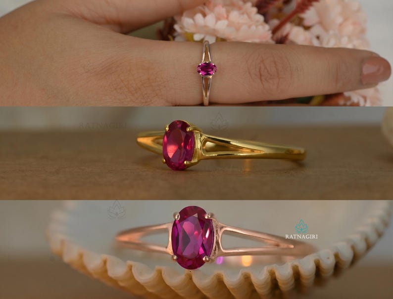 May include: A gold and rose gold ring with a large oval ruby gemstone. The ring is shown in three different views, including one on a finger and another resting on a seashell.