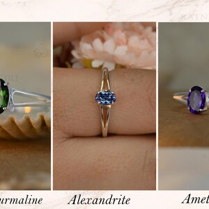 May include: Three silver rings with oval gemstones: green tourmaline, alexandrite, and amethyst. The rings are displayed against neutral backgrounds. The text below each ring identifies the gemstone.