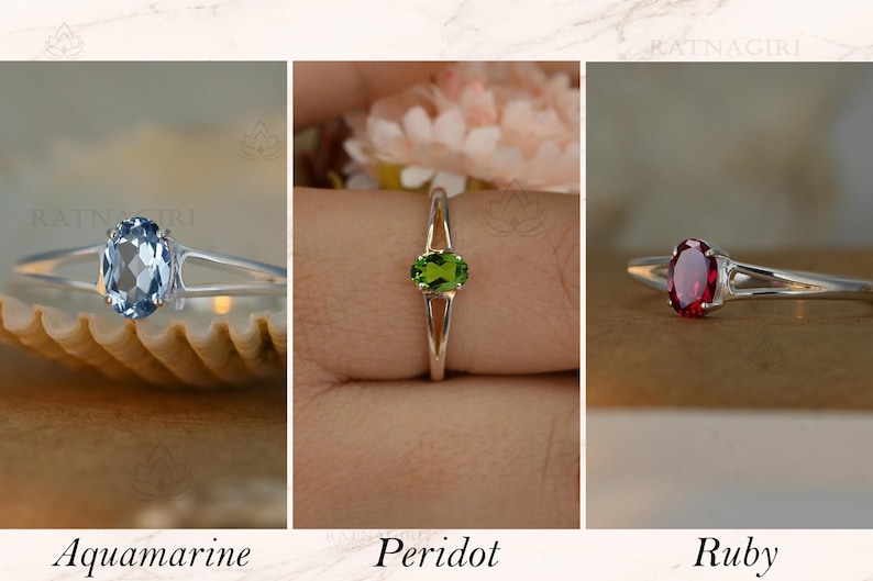 May include: Three rings with oval gemstones: aquamarine, peridot, and ruby. Each ring has a silver band. The aquamarine ring is on a seashell, the peridot ring is on a finger, and the ruby ring is on a neutral background. Text below reads "Aquamarine", "Peridot", and "Ruby".