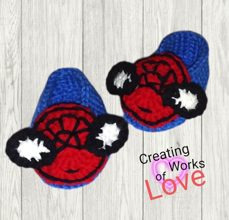Puede incluir: Un par de botines de beb&eacute; de crochet azul y rojo con un dise&ntilde;o de Spiderman. Los botines tienen un dise&ntilde;o de telara&ntilde;a blanca y negra en la parte delantera y ojos blancos y negros en los lados.