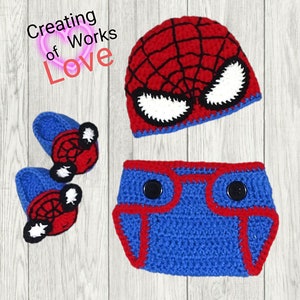 Puede incluir: Un conjunto de beb&eacute; de ganchillo en rojo, azul y negro con un dise&ntilde;o de Spiderman. El conjunto incluye un gorro, una cubierta de pa&ntilde;al y botines.