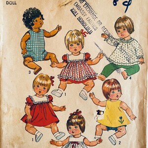 May include: Vintage Simplicity doll pattern, size 12"-13". The pattern features illustrations of six dolls in various outfits, including dresses, rompers, and a top with pants. The pattern number is 5947.