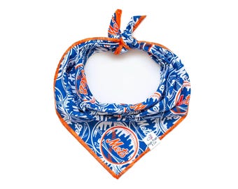 May include: Blue and orange dog bandana featuring the New York Mets logo and baseball-themed patterns. The bandana has an orange border and is tied at the top. The Mets logo is prominently displayed.