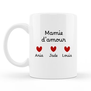 Peut inclure: Mug en céramique blanche avec le texte noir "Mamie d'amour" et trois cœurs rouges avec les noms "Aria", "Jade" et "Louis" en dessous.