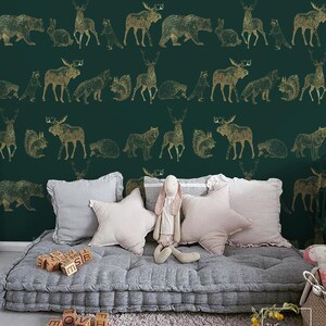 May include: A green and gold wallpaper with a repeating pattern of woodland animals. The animals include deer, moose, bears, wolves, squirrels, and raccoons. The wallpaper is shown in a nursery setting with a gray futon and pillows.