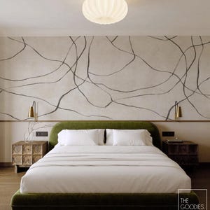 Op de afbeelding: Slaapkamer met een groen gestoffeerd bed en wit beddengoed, geflankeerd door houten nachtkastjes. De muur achter het bed is neutraal met zwarte abstracte lijnen. Een witte, geribbelde plafondlamp en messing wandkandelaars maken het decor compleet.