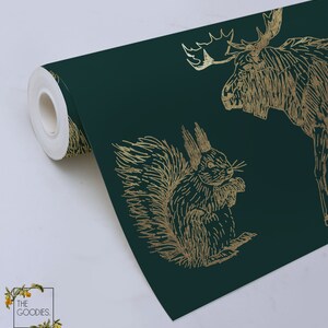 May include: A roll of dark green wallpaper with a gold foil pattern of a moose and a squirrel. The wallpaper is rolled up and the end of the roll is visible.