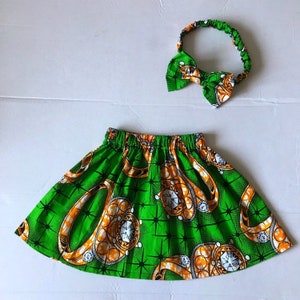 May include: A green and orange skirt with a diamond pattern and a matching headband. The skirt has an elastic waistband and is made of a soft, comfortable fabric.