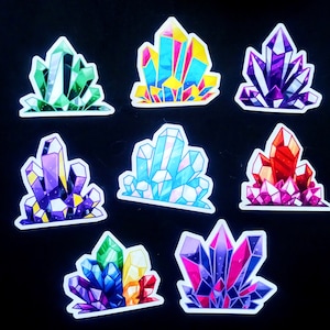 May include: Nine colorful crystal stickers with a variety of shapes and colors. The stickers are outlined in white and have a glossy finish.