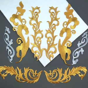 Può includere: Un set di applicazioni in tessuto ricamate in oro e argento con intricati motivi floreali. Le applicazioni sono perfette per aggiungere un tocco di eleganza a vestiti, accessori o progetti di arredamento per la casa.
