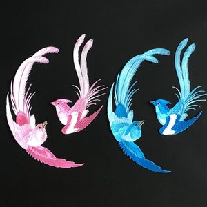 May include: Two pairs of embroidered bird appliques. One pair is pink and white, the other is blue and white.