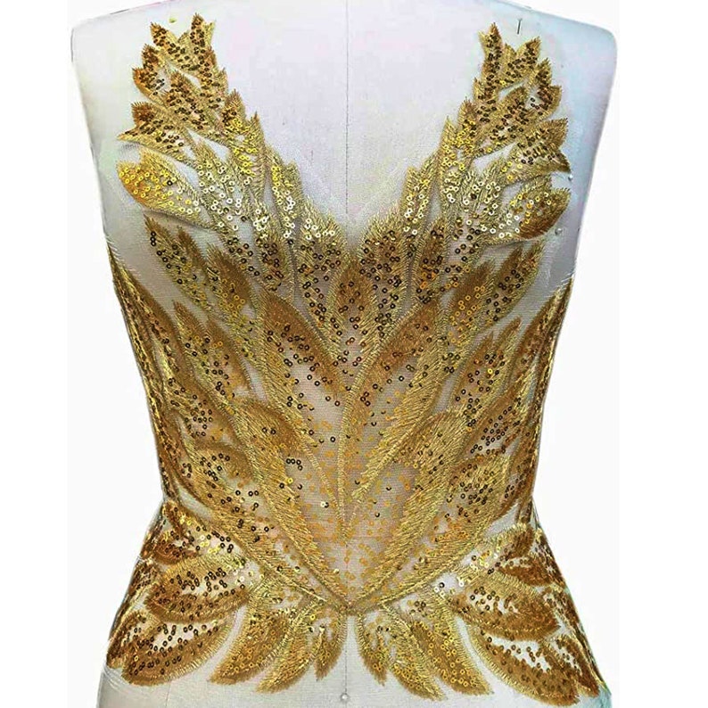 May include: Gold sequined applique with a leaf design. This decorative embellishment is perfect for adding a touch of sparkle to clothing, bags, or home decor projects.