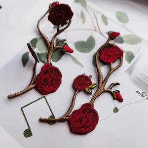 Puede incluir: Parches florales bordados con rosas rojo oscuro, tallos marrones y detalles verdes. Estos parches decorativos son ideales para añadir un toque de elegancia a la ropa, accesorios o proyectos de manualidades. Los parches están intrincadamente detallados.