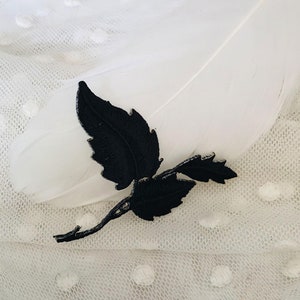 Puede incluir: Aplique de encaje negro con un delicado diseño de hojas. El aplique es perfecto para añadir un toque de elegancia a la ropa, las manualidades o la decoración del hogar.