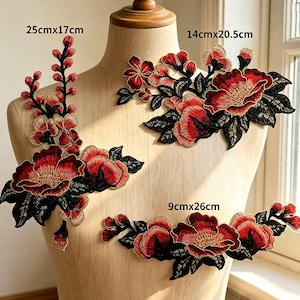 May include: Three floral embroidered patches featuring red and gold petals with black leaves. The vertical patch measures 25cm x 17cm, the top horizontal patch measures 14cm x 20.5cm, and the bottom horizontal patch measures 9cm x 26cm.
