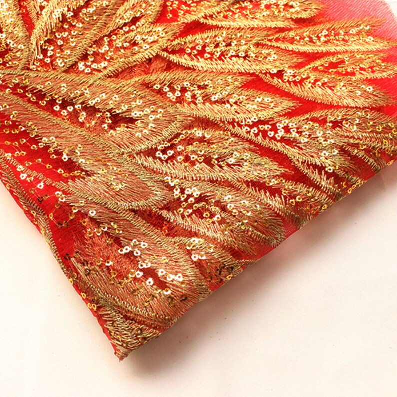 May include: Red mesh fabric with gold embroidered feather designs and sequins.