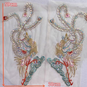 May include: Two embroidered phoenix patches, each 59cm tall and 30cm wide. The patches feature gold, pink, blue, and silver sequins and beads. The phoenixes have detailed wings and tail feathers, with a cloud-like design at the base.